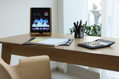 Photo of Workplace with tablet and stationery in office. Forex trading
