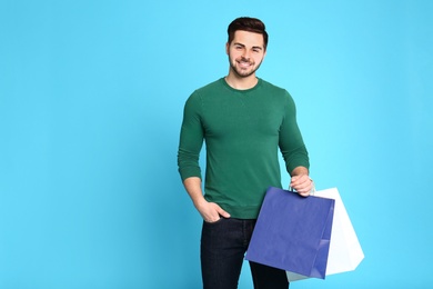 Photo of Portrait of young man with paper bags on blue background