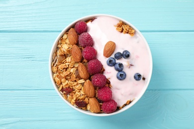 Photo of Tasty homemade granola served on blue wooden table, top view. Healthy breakfast