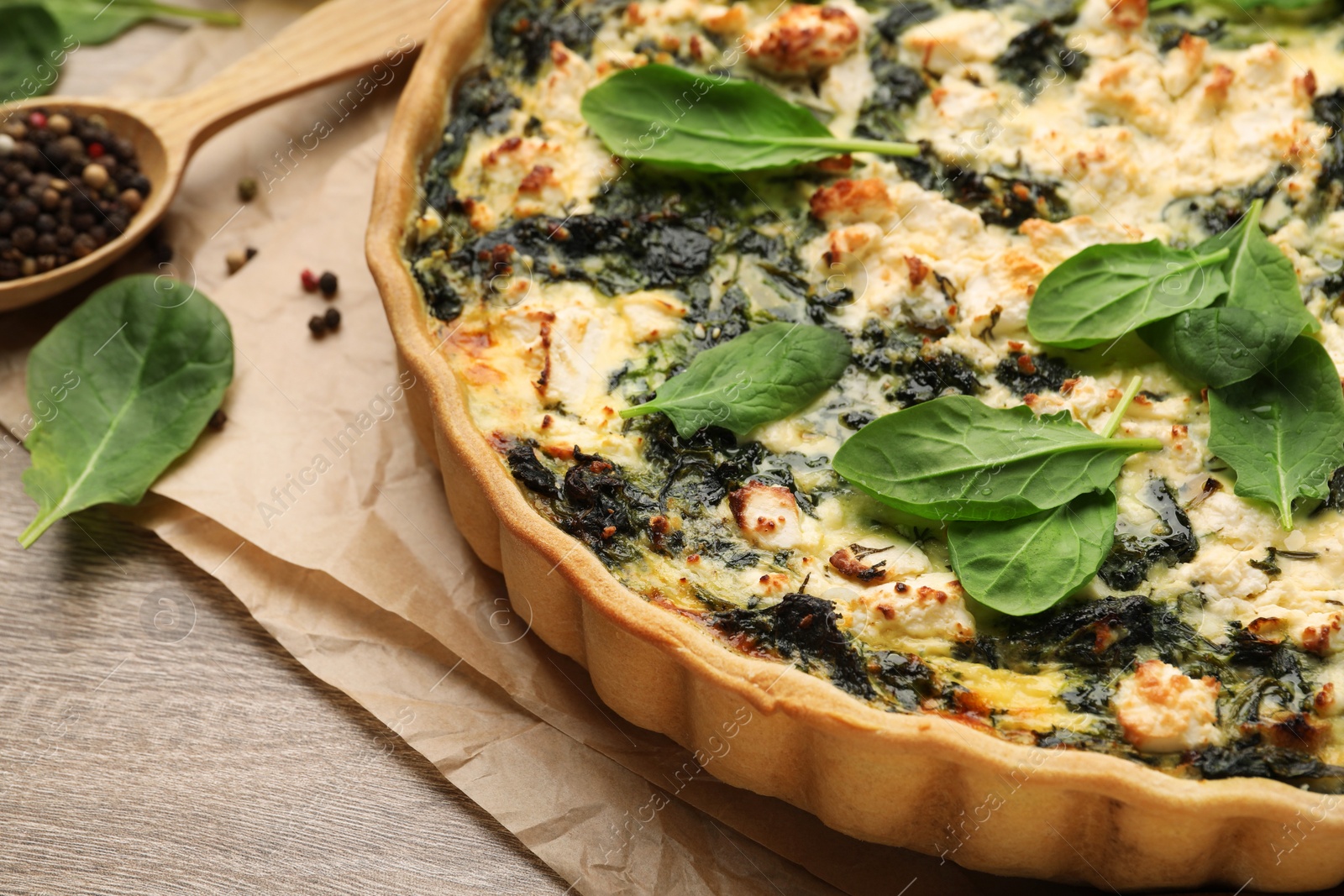 Photo of Delicious homemade spinach quiche on table, closeup