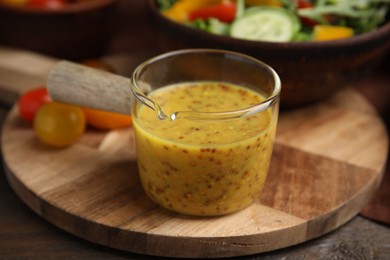 Photo of Tasty vinegar based sauce (Vinaigrette) on wooden table, closeup