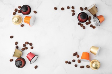 Photo of Many coffee capsules and beans on white marble table, flat lay. Space for text