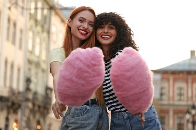 Photo of Happy friends with cotton candy on city street