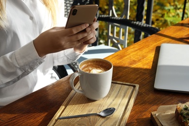 Photo of Blogger taking photo of coffee at cafe, closeup