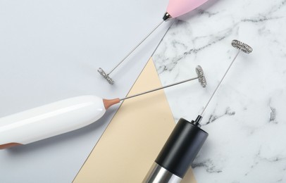 Milk frother wands on color background, flat lay