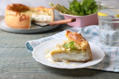 Photo of Freshly baked rhubarb pie with cream cheese, mint leaves and almond flakes on grey wooden table