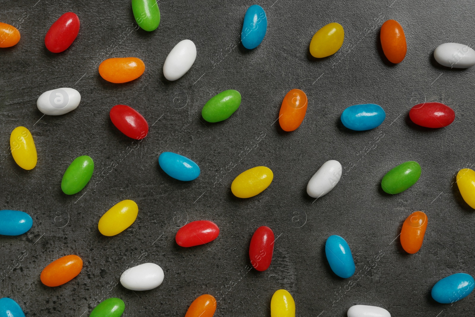 Photo of Flat lay composition with delicious jelly beans on grey background