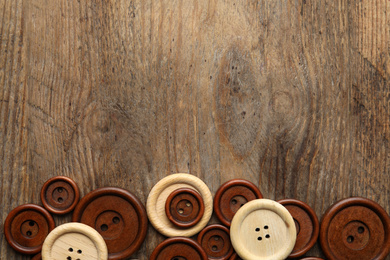 Photo of Many sewing buttons on wooden background, flat lay. Space for text