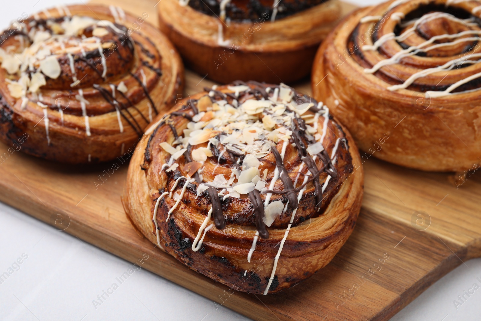 Photo of Different delicious rolls on white table, closeup. Sweet buns