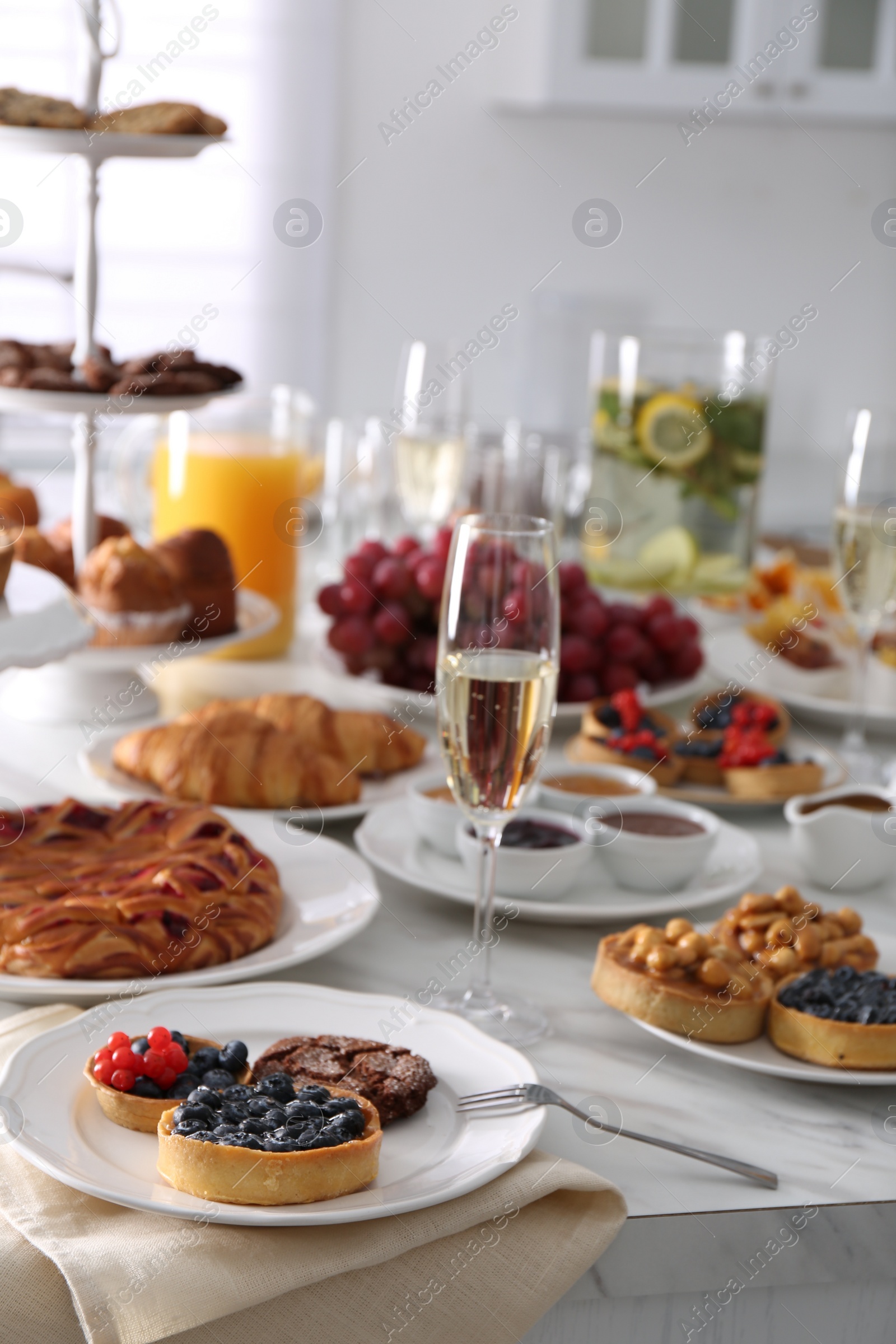 Photo of Variety of snacks on white marble table in buffet style indoors