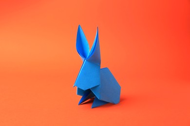 Photo of Origami art. Beautiful paper rabbit on orange background