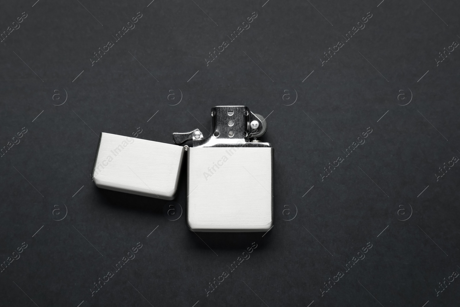 Photo of Gray metallic cigarette lighter on black background, top view
