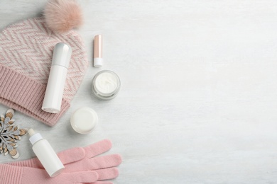 Photo of Flat lay composition with different cosmetic products on light table, space for text. Winter care