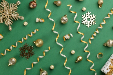 Photo of Flat lay composition with serpentine streamers and Christmas decor on green background