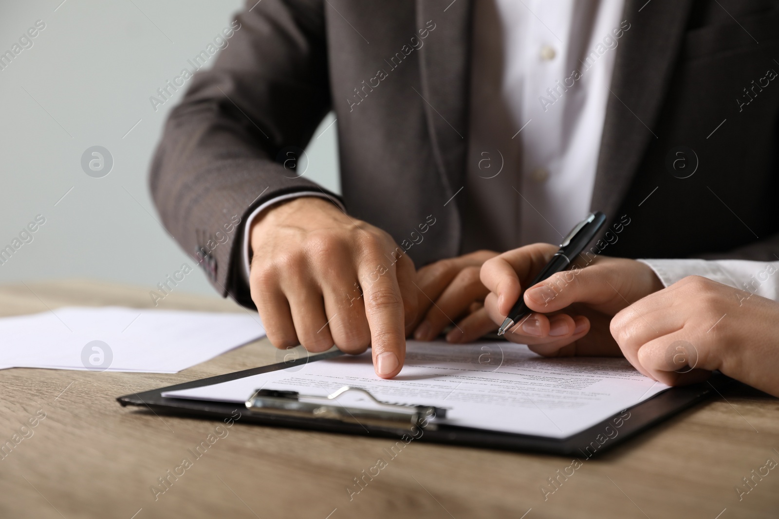 Photo of Businesspeople working with document at table indoors, closeup