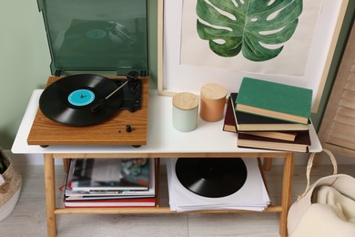 Stylish turntable with vinyl record console table in room