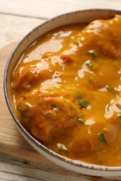 Tasty chicken curry on wooden table, closeup