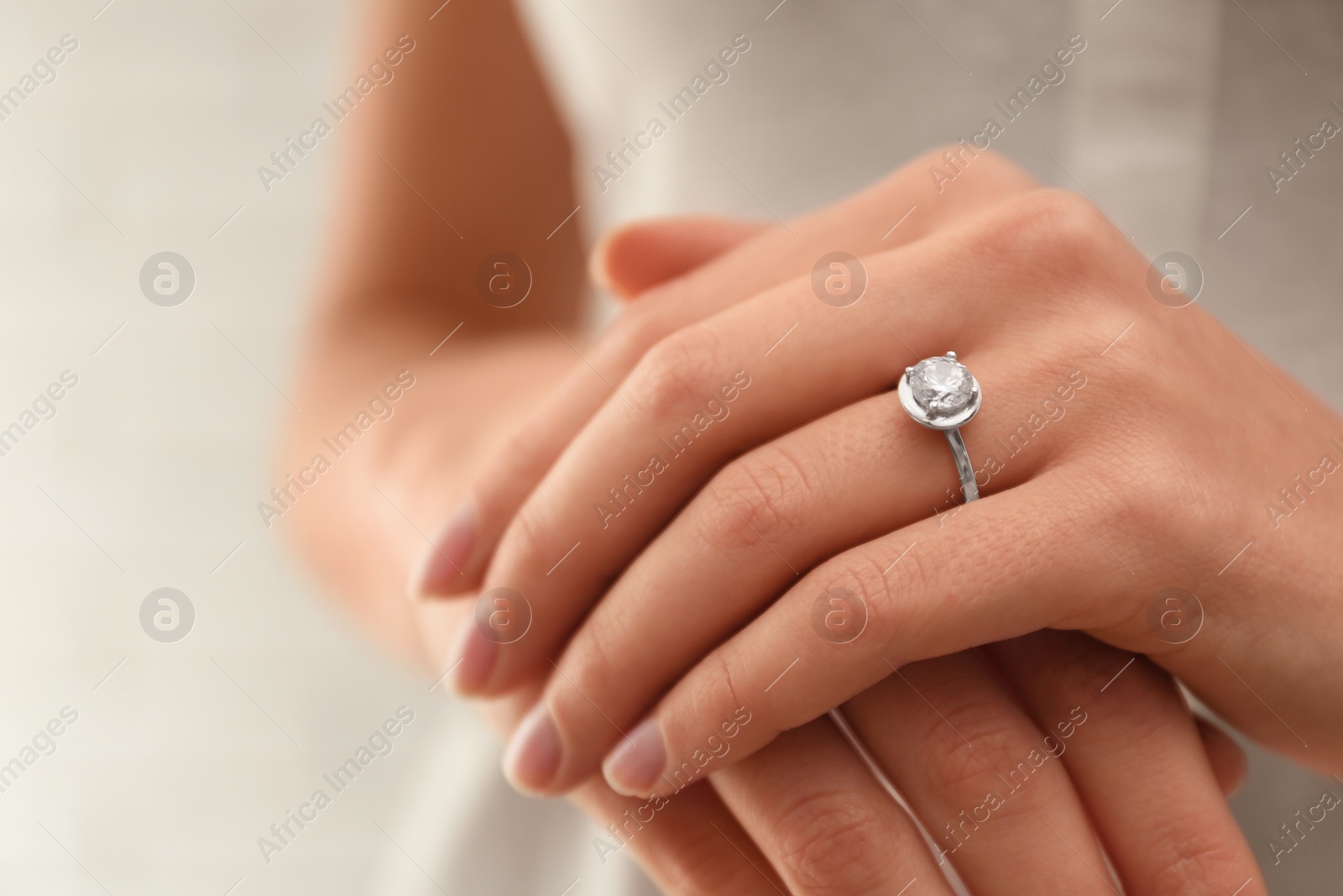 Photo of Young bride wearing beautiful engagement ring, closeup