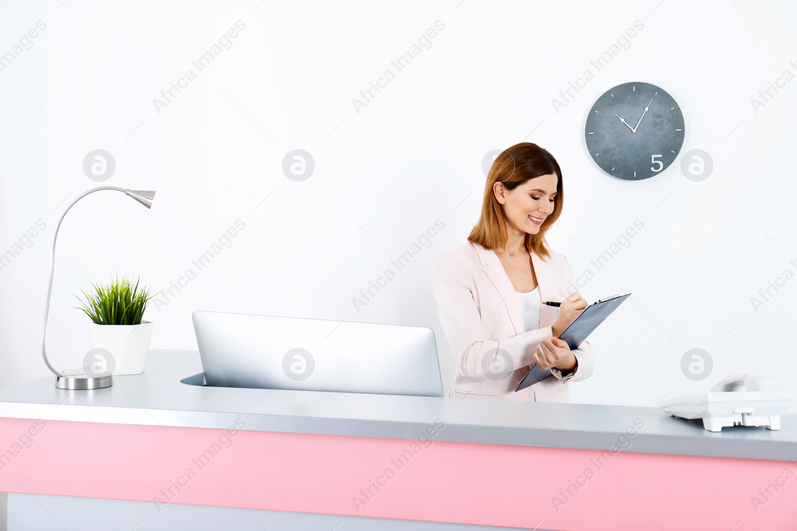 Photo of Beautiful woman working at reception desk in beauty salon