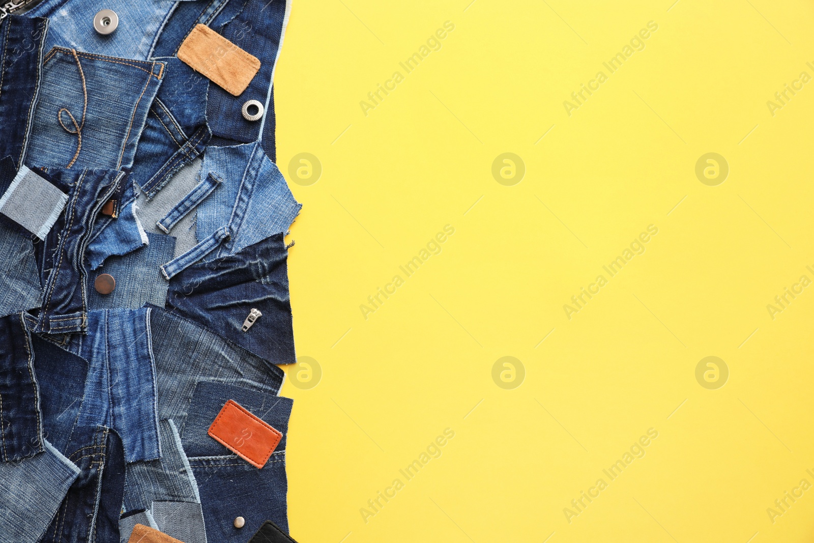 Photo of Flat lay composition with patches of old jeans on yellow background. Space for text