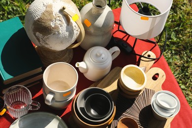 Photo of Many different items on table outdoors, above view. Garage sale