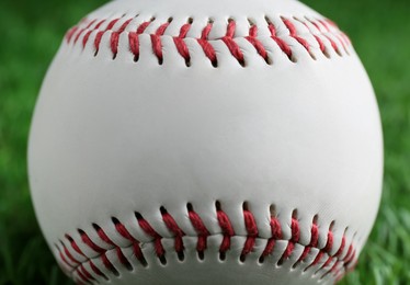 Photo of Baseball ball on green grass, closeup. Sports game
