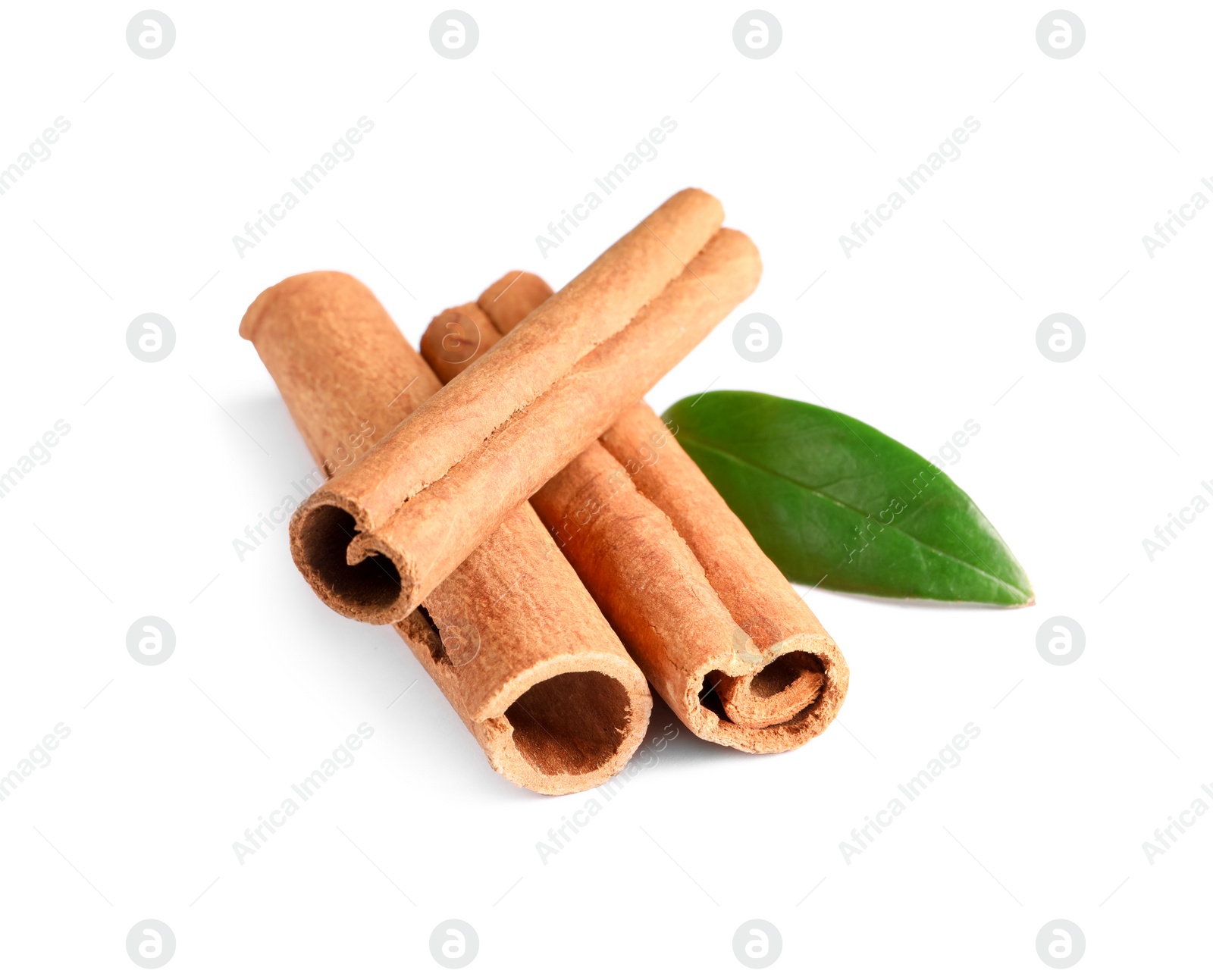 Photo of Cinnamon sticks and green leaf isolated on white