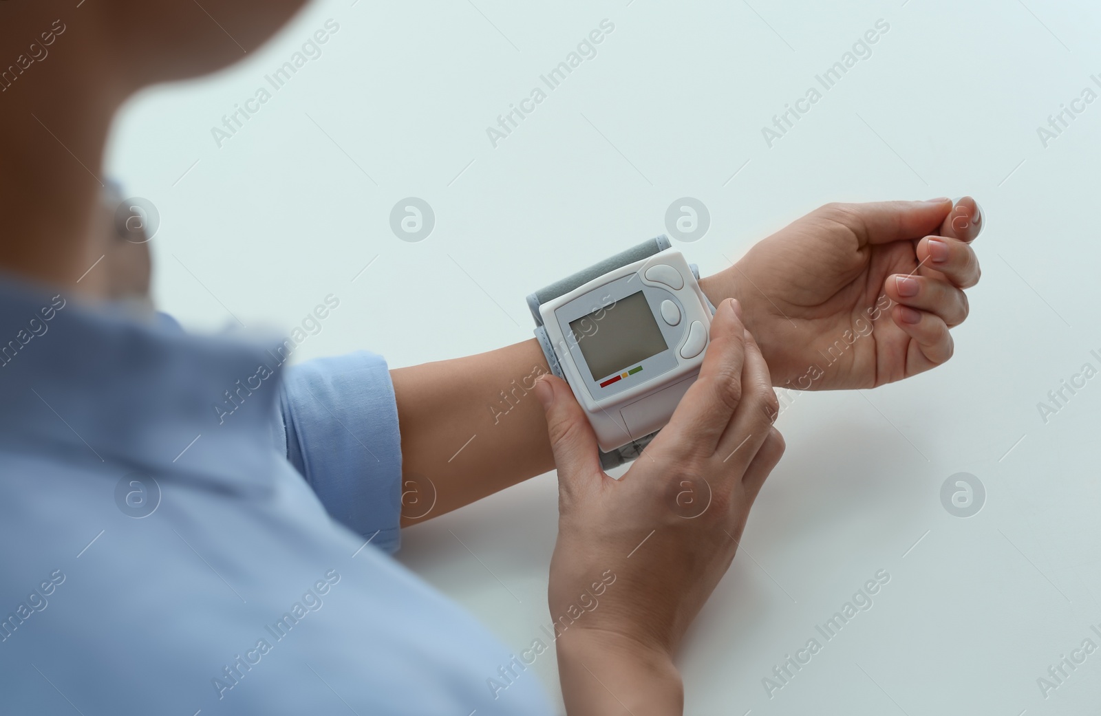 Photo of Woman checking blood pressure with sphygmomanometer at table, closeup. Cardiology concept