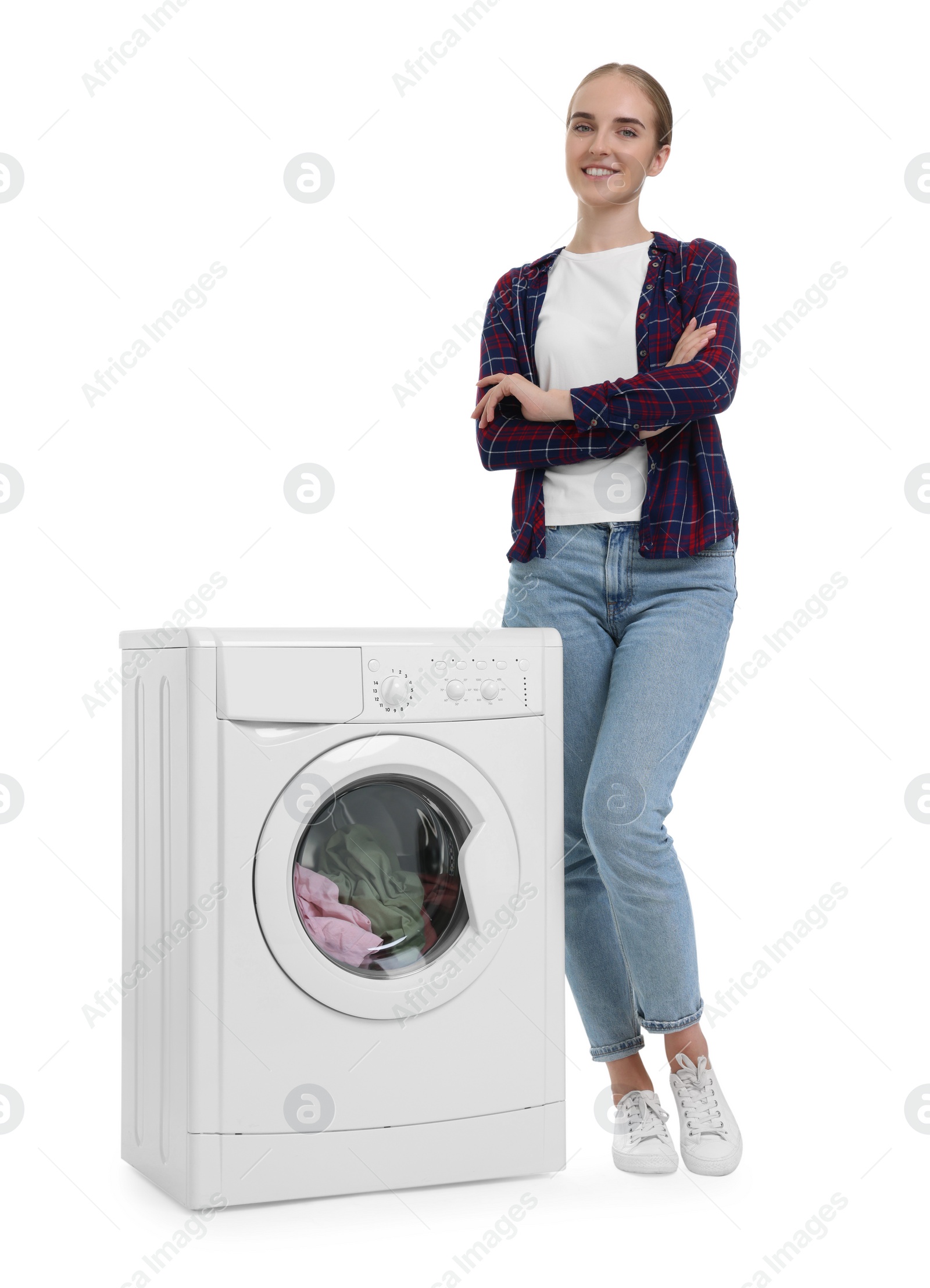 Photo of Beautiful young woman near washing machine with laundry on white background