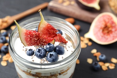 Photo of Tasty homemade granola dessert on dark grey table, closeup. Healthy breakfast