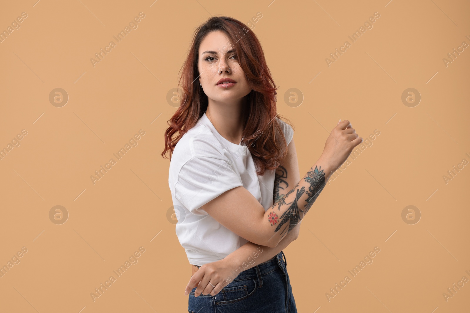 Photo of Portrait of beautiful tattooed woman on beige background