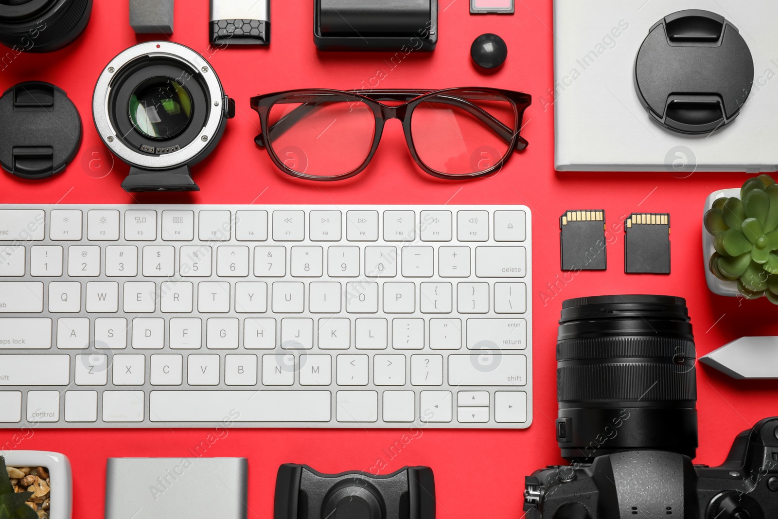 Photo of Flat lay composition with camera and video production equipment on red background