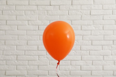 Photo of Bright balloon near brick wall. Celebration time