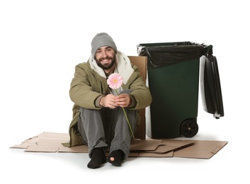 Poor homeless man with flower near trash bin isolated on white