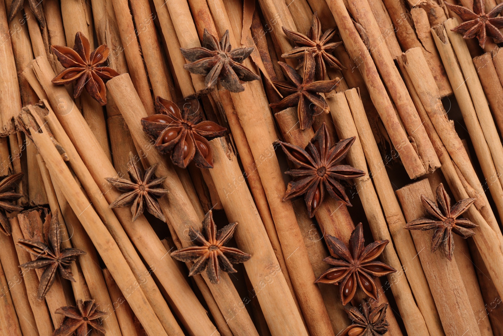 Photo of Aromatic cinnamon sticks and anise as background, top view