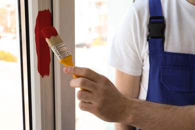 Man painting window frame at home, closeup