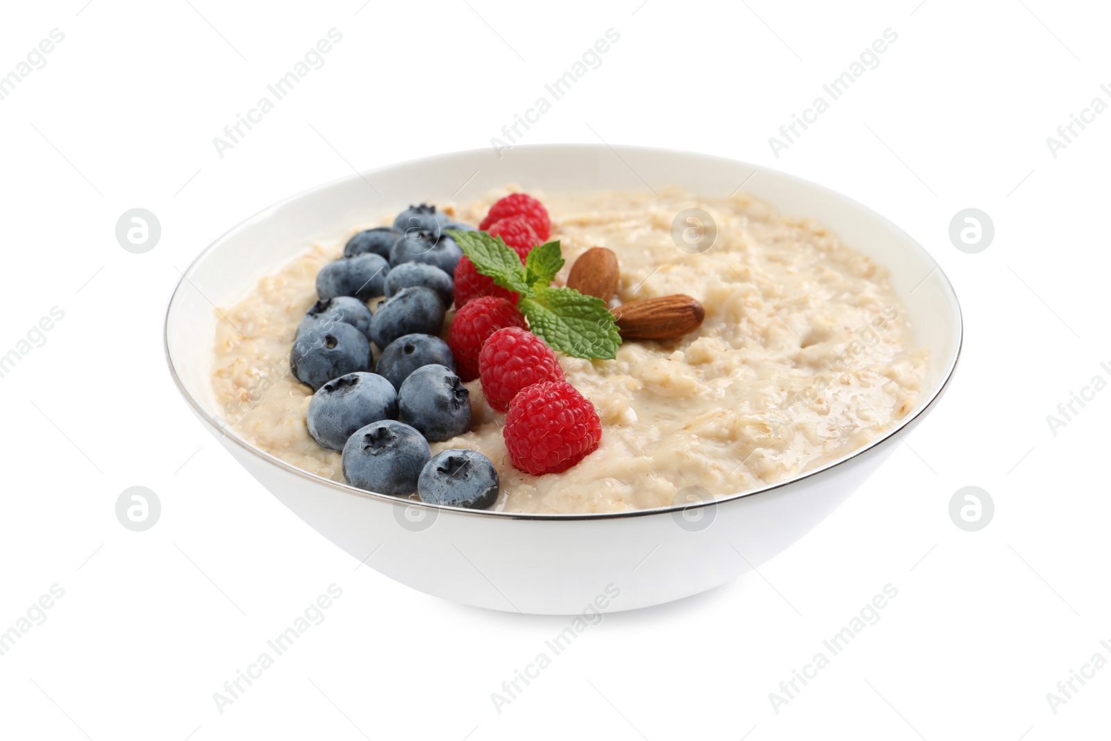Photo of Tasty oatmeal porridge with raspberries, blueberries and almond nuts in bowl on white background