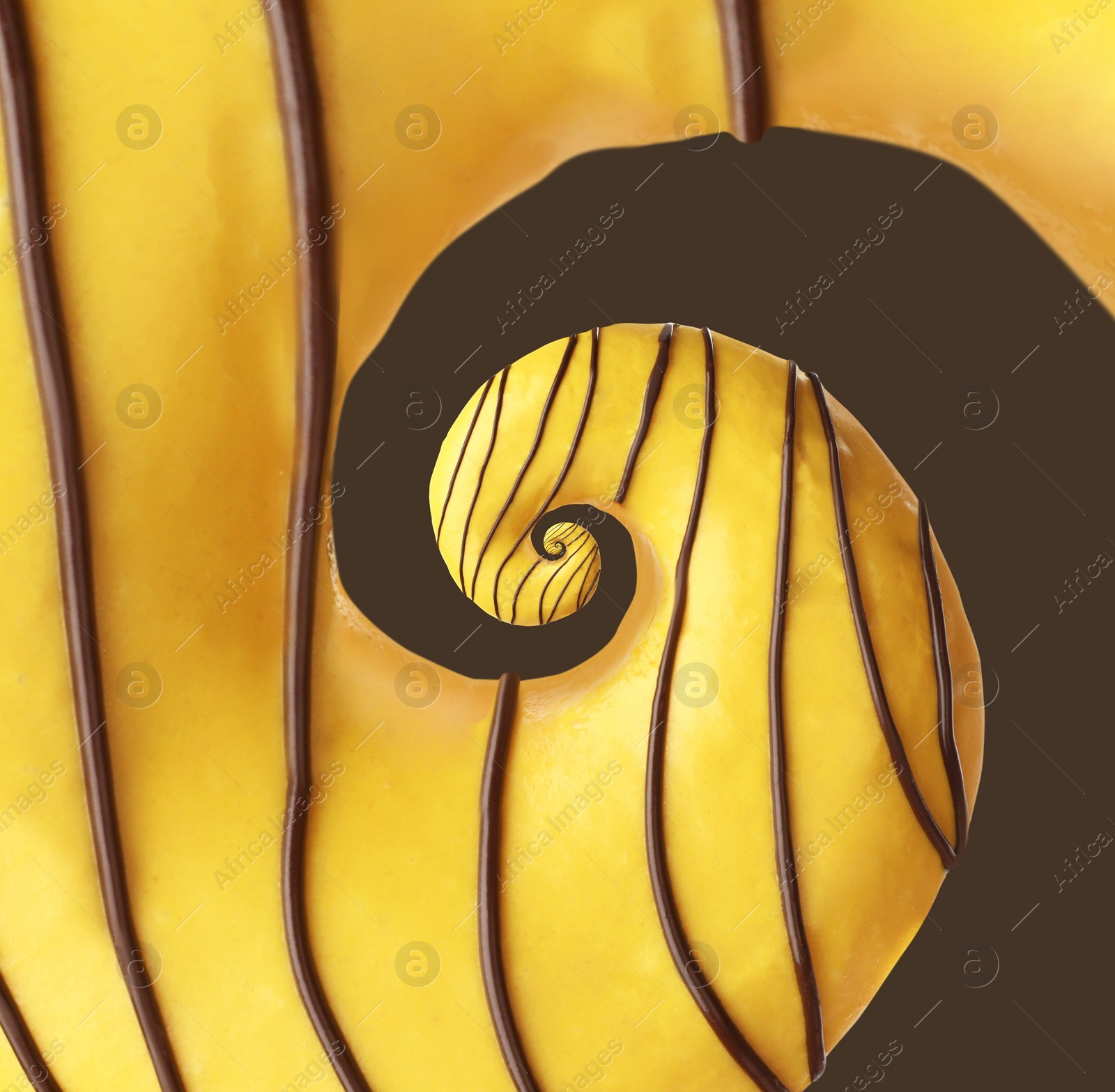 Image of Twisted donut with banana icing and chocolate topping on brown background, spiral effect
