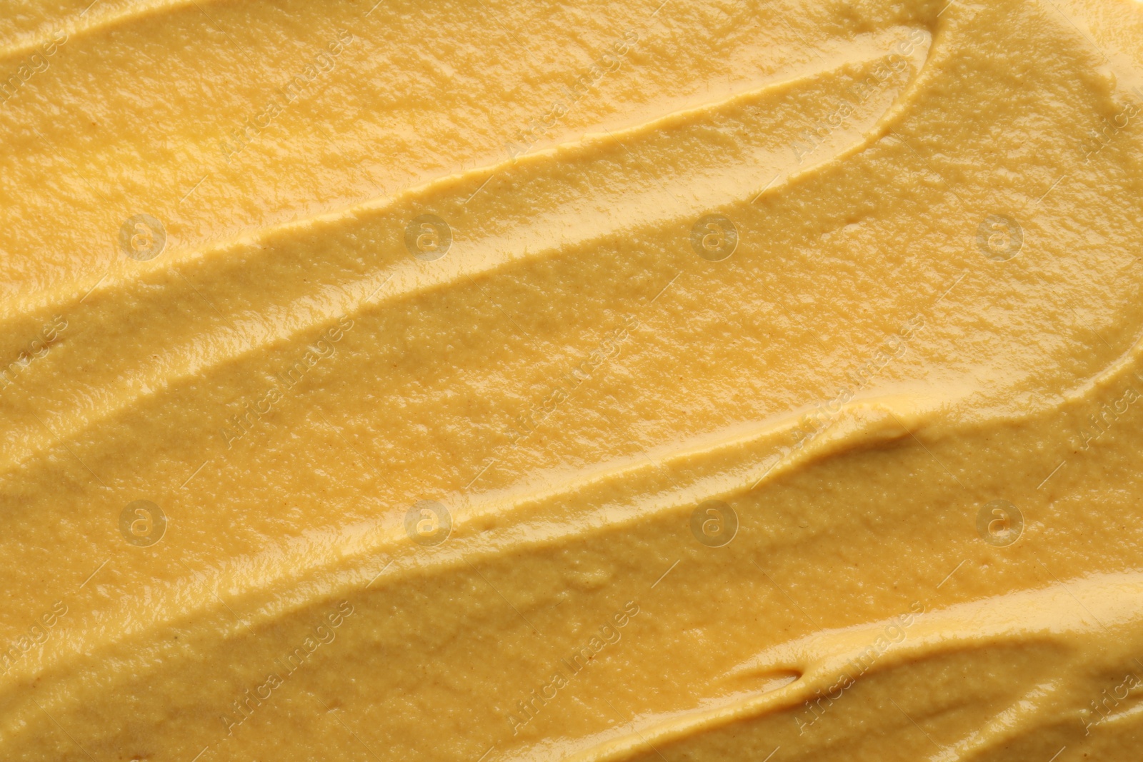 Photo of Fresh tasty mustard sauce as background, top view