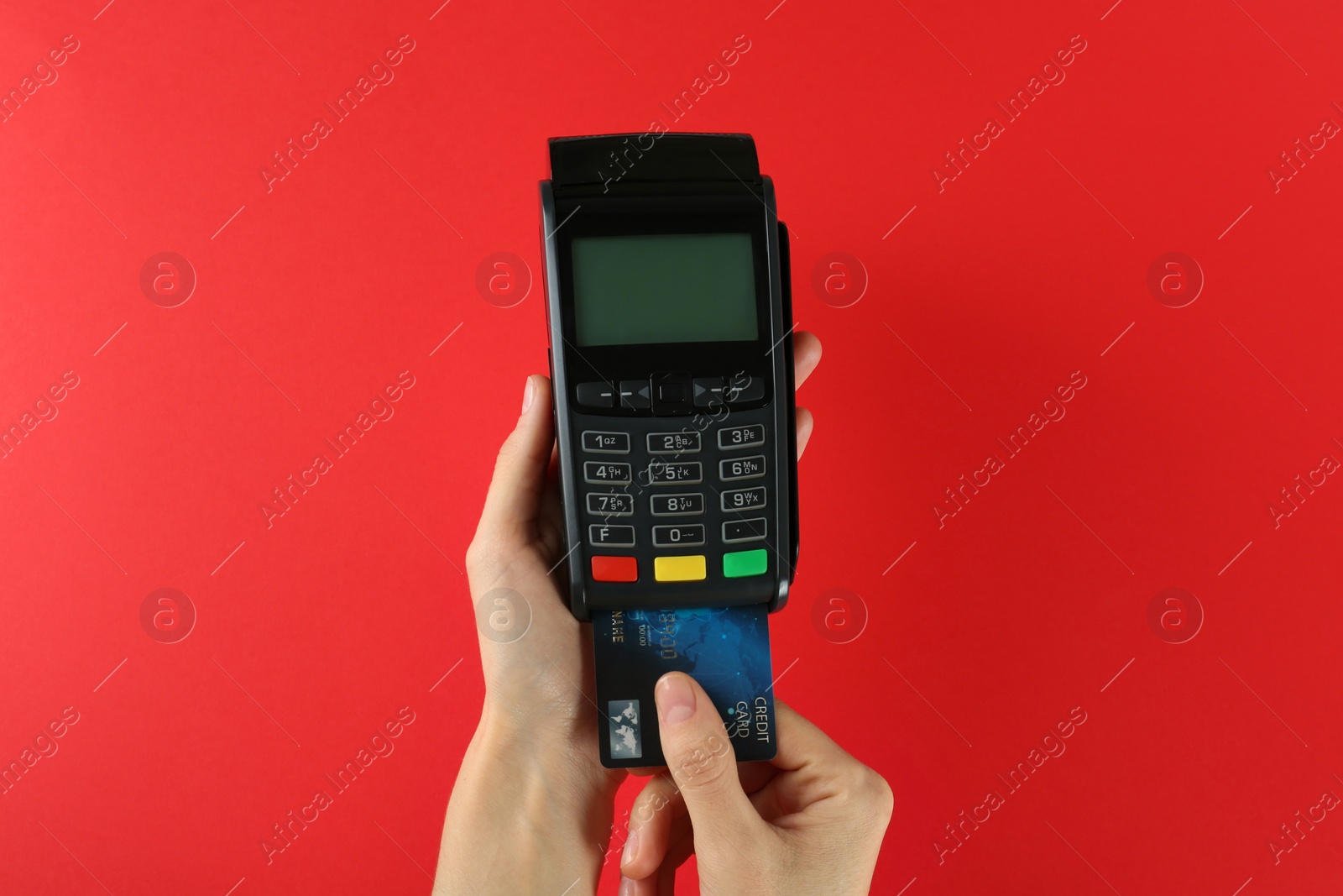 Photo of Woman with credit card using modern payment terminal on red background, closeup