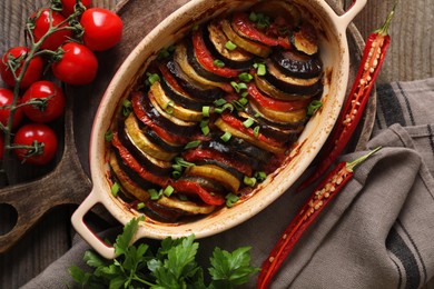 Delicious ratatouille and ingredients on table, flat lay