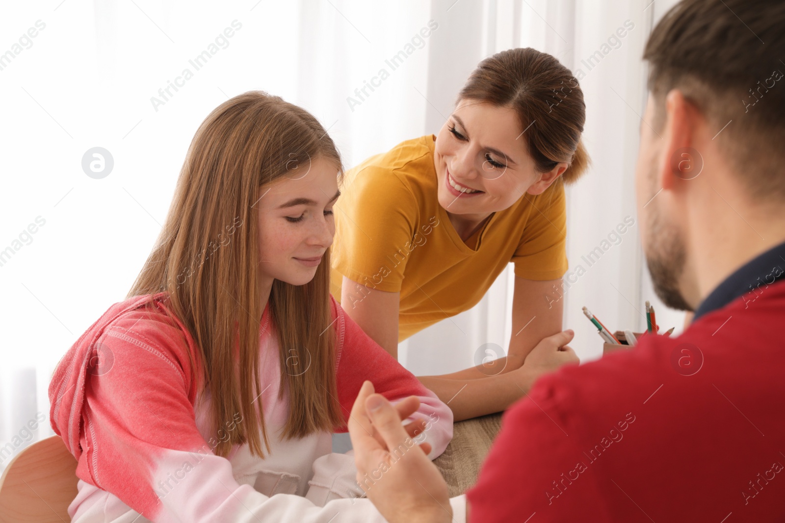 Photo of Parents helping their teenager daughter with homework indoors