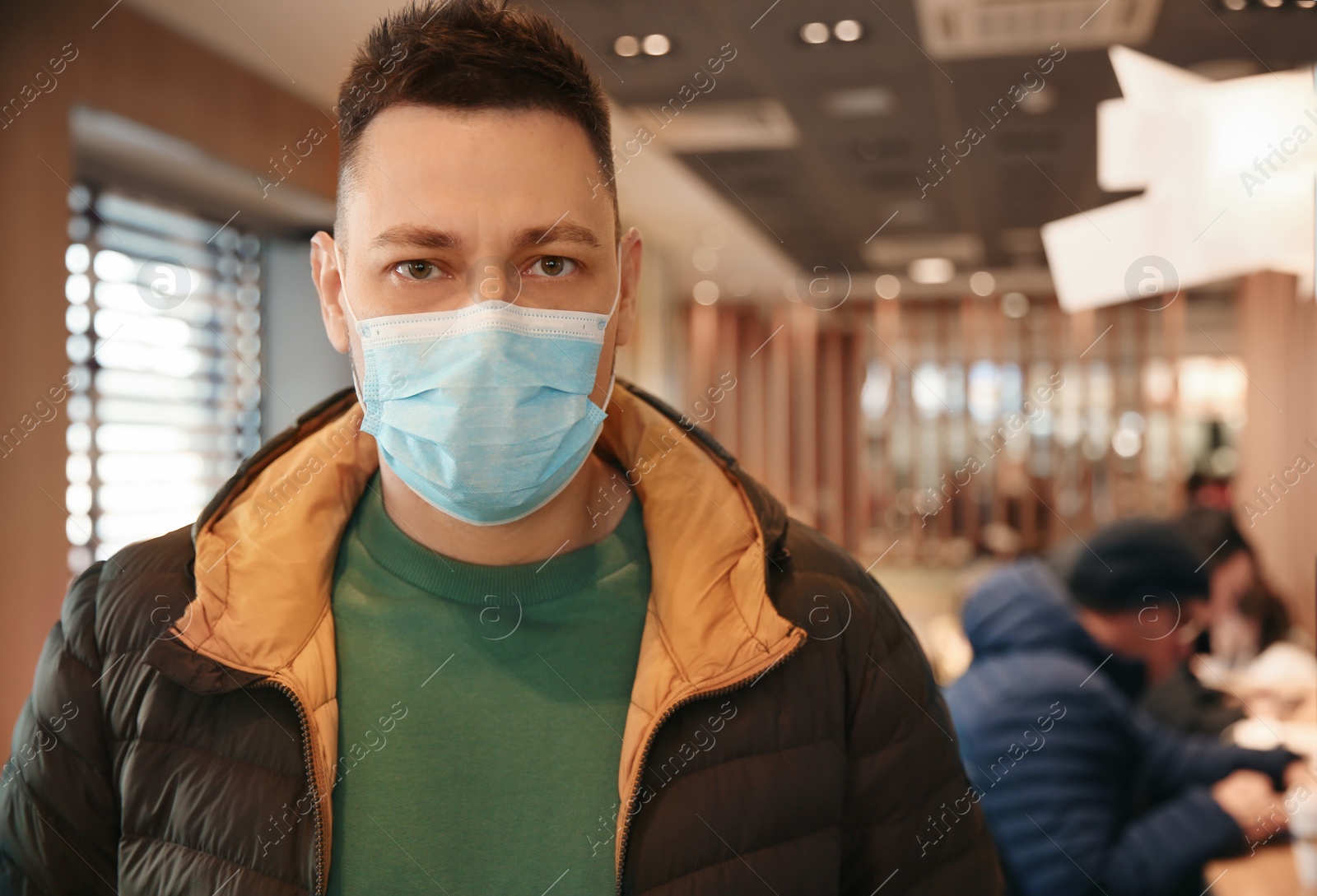 Photo of Man with disposable mask in cafe. Virus protection