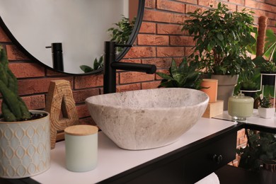 Stylish sink and beautiful green houseplants in bathroom. Interior design