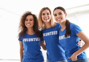 Photo of Portrait of happy female volunteers in uniform indoors