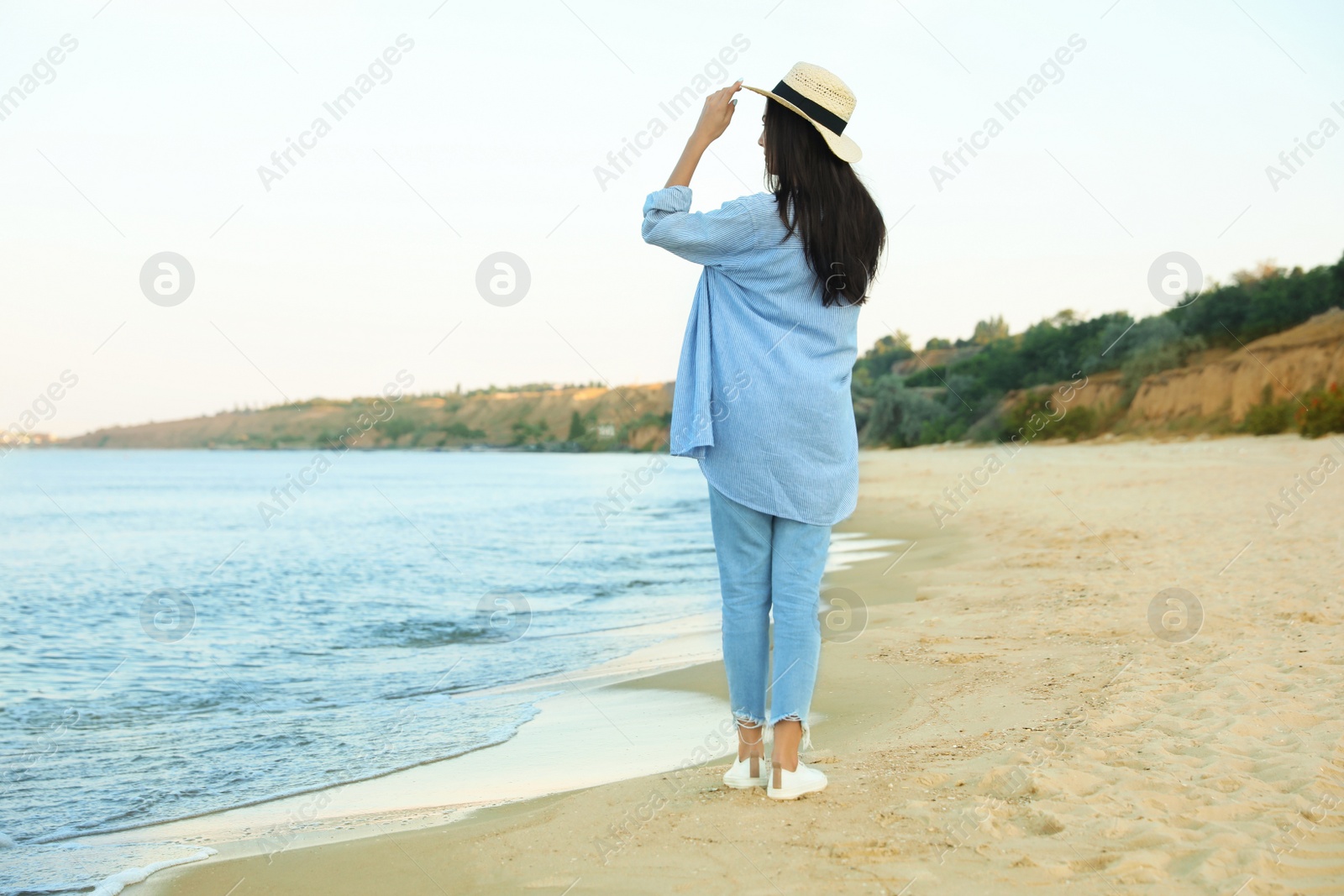 Photo of Beautiful young woman in casual outfit on beach