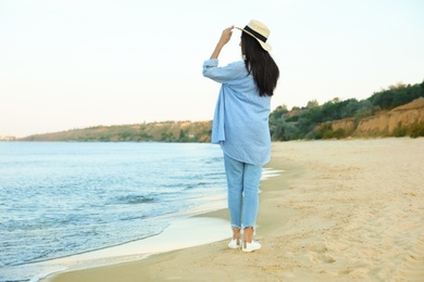 Photo of Beautiful young woman in casual outfit on beach