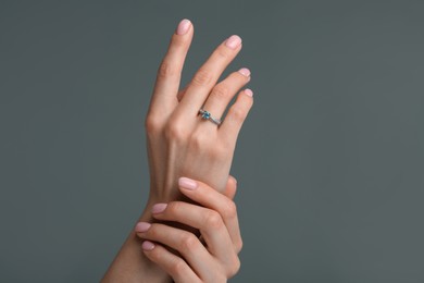 Photo of Woman with elegant ring on dark grey background, closeup
