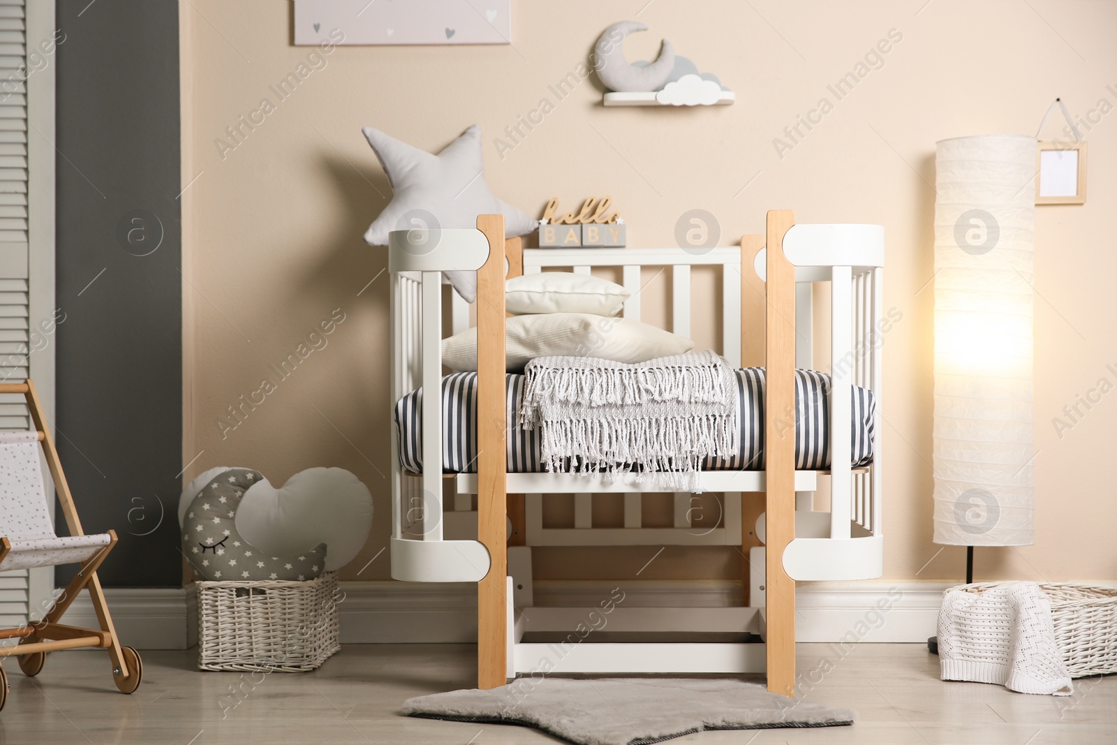 Photo of Cute baby room interior with modern crib and toys