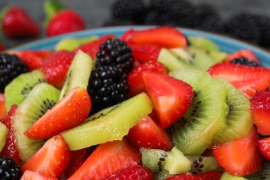 Photo of Delicious fresh fruit salad on plate, closeup